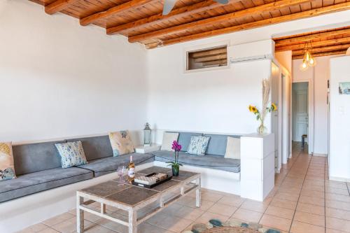 a living room with a couch and a table at Yalos Mykonos Ornos Pouli private apartments w shared swimming pool in Mýkonos City