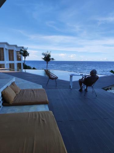 a deck with a bed and a table and the ocean at Trogon's Perch in San Isidro