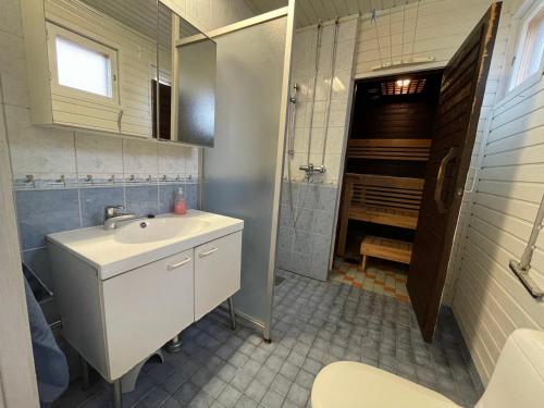 a bathroom with a sink and a mirror and a shower at Villa Red House in Parikkala