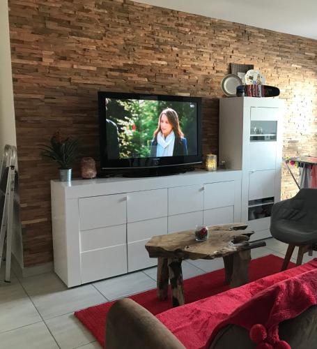 - un salon avec une télévision murale dans l'établissement Chambre cosy privée Villeurbanne proximité centre ville place de parking privée selon disponibilité, à Villeurbanne