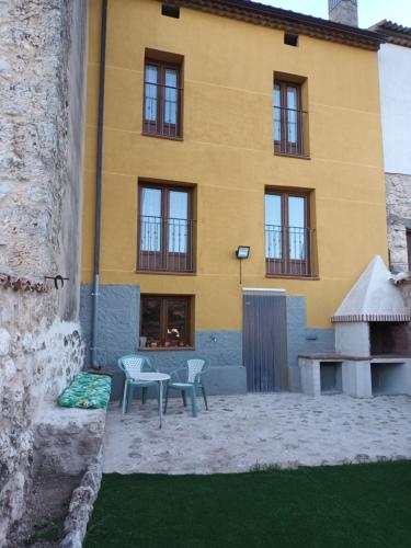a yellow building with a table and chairs in front of it at Apartamentos turísticos Ribera Natura in San Martín de Rubiales