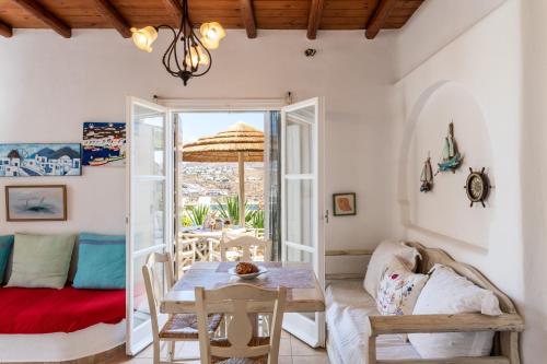 a living room with a table and a couch at Yalos Mykonos Ornos Pouli private apartments w shared swimming pool in Mýkonos City