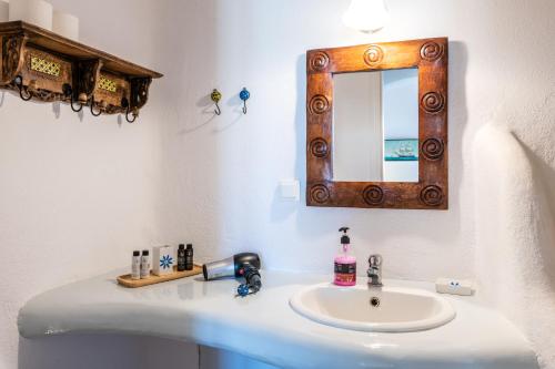 a bathroom with a sink and a mirror at Yalos Mykonos Ornos Pouli private apartments w shared swimming pool in Mýkonos City