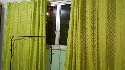 a window with green curtains in a room at New Garden View GF Double Room FREE parking in Batu Unjor