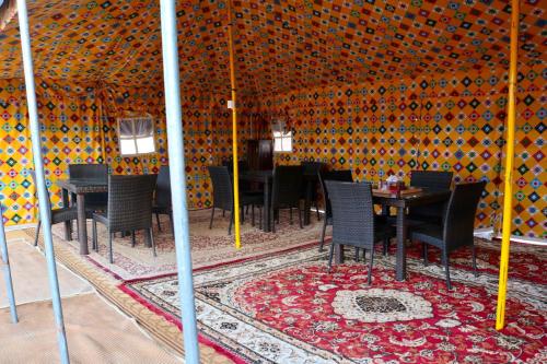 Badīyah的住宿－Rashid Desert Private Camp，帐篷内的用餐室配有桌椅