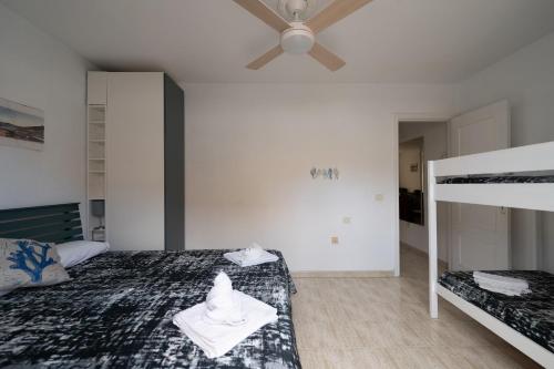 a bedroom with a bed and a ceiling fan at Arenitas Beach Un oasis junto al mar in Candelaria