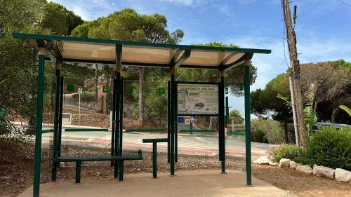 a bus stop with a sign in front of a street at Casa Carolina - This One in Higuerón with Quality and Peace in Mijas