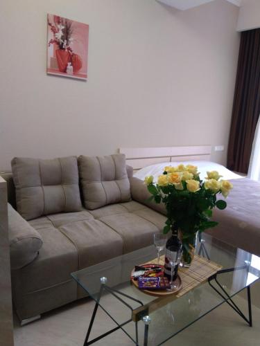 a living room with a couch and a glass table with flowers at Tsaghkadzor, Alvina Complex Apartment 163 in Tsaghkadzor