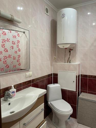 a bathroom with a white toilet and a sink at Boryspil Airport Luxury apartment in Boryspilʼ