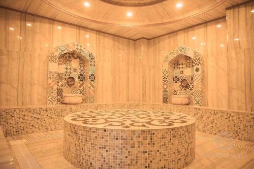 Premier Palace Baku في باكو: حمام مع طاولة مستديرة ومرآتين