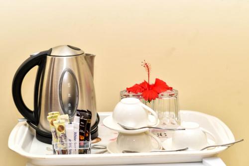 a tea kettle on a white tray with dishes at Minara Miwili - Forodhani Park in Zanzibar City