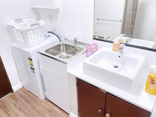een witte badkamer met een wastafel en een spiegel bij NO PARTY ALLOWED,Sea view 5 bedroom house in Wellington