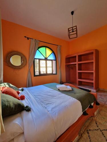 a bedroom with a large bed and a window at Villa Nouran - Chambre Hôte in Ghazoua