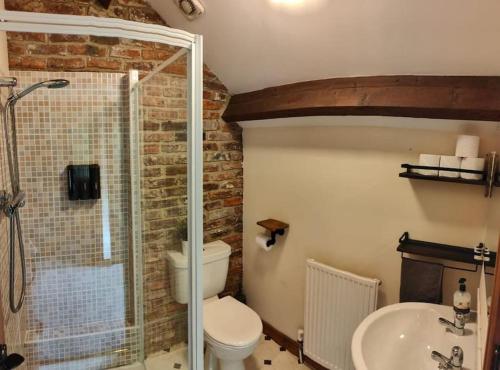 a bathroom with a shower and a toilet and a sink at Stunning 2 Bedroom Guest House with Hot Tub in Durham