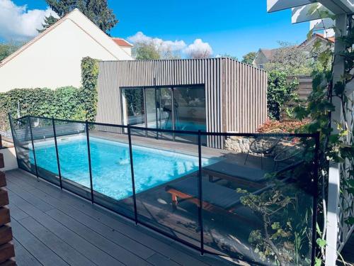 a balcony with a swimming pool on a house at Appartement proche Astérix, Stade de France, Chantilly, Roissy, piscine saisonnière in La Chapelle-en-Serval