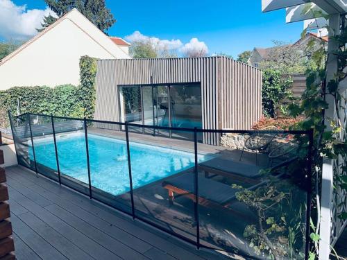 - un balcon avec une piscine dans une maison dans l'établissement Appartement proche Astérix, Stade de France, Chantilly, Roissy, piscine saisonnière, à La Chapelle-en-Serval