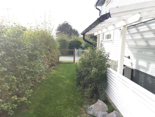 a yard next to a white house with a fence at Yksityinen kellarikerros omalla sisäänkäynnillä, Pietarsaari in Pietarsaari