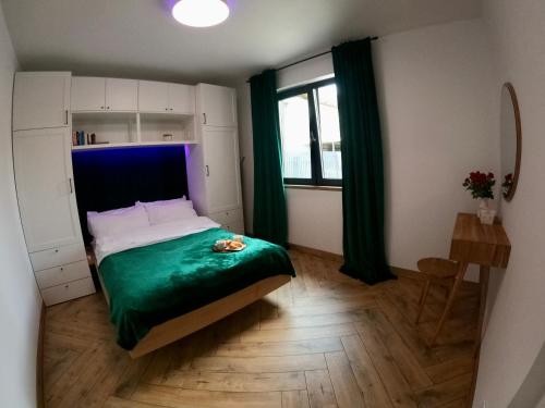 - une chambre avec un lit doté d'une couverture verte dans l'établissement Widok 3B, à Piechowice