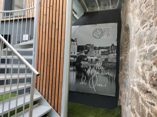 a stairway with a sign on the side of a building at La Maison du Quai Triplex de charme 4 étoiles en hyper centre avec SPA in Landerneau