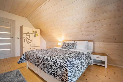 sypialnia z łóżkiem i drewnianą ścianą w obiekcie Daglezja VIP w mieście Kołczewo