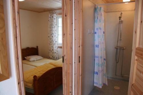 um pequeno quarto com uma cama e uma janela em Hornborgasjöns Stugby em Bjällum