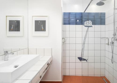 a white bathroom with a shower and a sink at Hotel Kalura in Cefalù