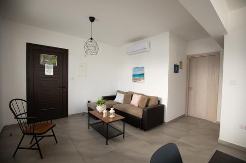 a living room with a couch and a table at Carme at the Beach - Mythical Sands in Paralimni