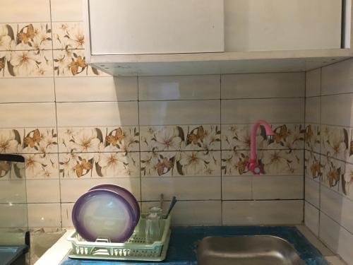 a kitchen with a sink and a tile wall at Residence MaryHouse - Free Breakfast and Taxi From Airport in Cotonou