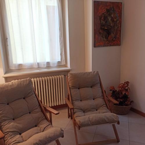 a living room with two chairs and a window at Juli Richi holidays in Croviana