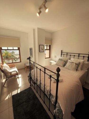a bedroom with a bed and a chair and a window at Duplex ORION in Tazacorte