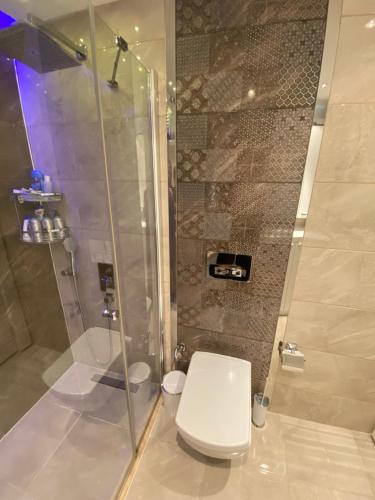 a bathroom with a shower and a white toilet at Best Home 17 Kleopatra in Alanya