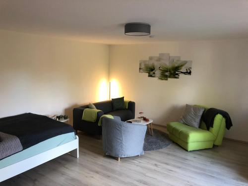 a bedroom with a bed and a couch and a chair at Ferienwohnung Härtings Hygge in Obernkirchen