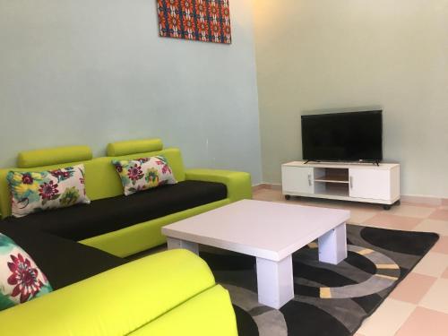 a living room with a couch and a tv at Residence MaryHouse - Free Breakfast and Taxi From Airport in Cotonou