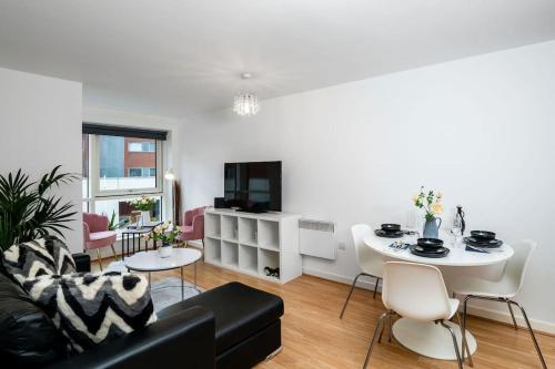 a living room with a couch and a table at Central Gunwharf Quays Two Bedroom apartment in Portsmouth
