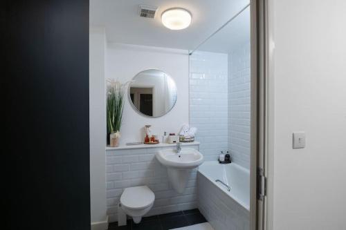 a bathroom with a sink and a toilet and a mirror at Central Gunwharf Quays Two Bedroom apartment in Portsmouth