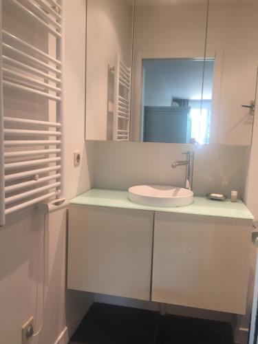 une salle de bain avec un lavabo et un miroir dans l'établissement T2 à proximité de la mer avec parking, à Marseille
