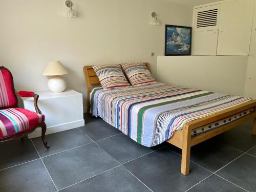 une chambre avec un lit et une chaise dans l'établissement T2 à proximité de la mer avec parking, à Marseille