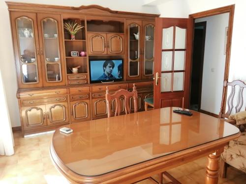 una sala de estar con un gran armario de madera con TV en Barrero 47 en Igualeja