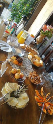 Pousada Relíquias do Mar في أرايال دو كابو: طاولة خشبية طويلة عليها صحون طعام