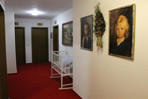 a hallway with some pictures on the wall at Hotel Schäfflerhof in Bischofsmais