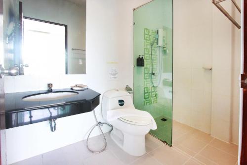 ein Bad mit einem WC, einem Waschbecken und einer Dusche in der Unterkunft The Langstan Suites in Nai Harn Beach