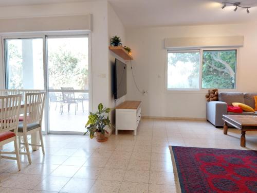 a living room with a couch and a table at Happy Vacation House in Zikhron Ya‘aqov