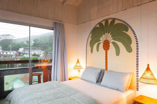 a bedroom with a palm tree mural on the wall at Sea Wolf Surf Hostel in Florianópolis