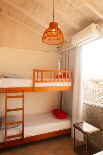 a bedroom with two bunk beds and a window at Sea Wolf Surf Hostel in Florianópolis