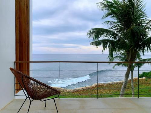 a chair sitting on a balcony looking out at the ocean at Trogon's Perch in San Isidro