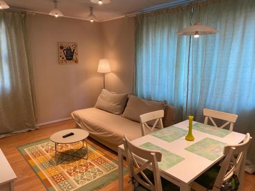 sala de estar con mesa y sofá en IGI WHITE FLAT with free private parking, en Cluj-Napoca