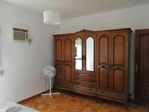 a room with a large wooden cabinet and a fan at Barrero 47 in Igualeja