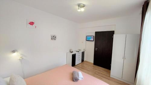 a bedroom with a pink bed and a black door at 3 Rooms Apartment, Top Center, 1st Floor, AUBG, WiFi, PC i5 SSD, Tablet, AndroidMiTvBox, 3 LED TVs 200 Channels, Long Terrace, Self-Easy-Late Check-in, Stay Before Greece in Blagoevgrad