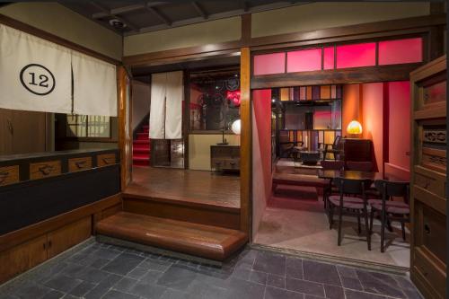 Zimmer mit einem Tisch, Stühlen und einem Spiegel in der Unterkunft ダース旅館＆カフェ（Dozen-Ryokan＆Cafe） in Nishi-kujō-Toriiguchichō
