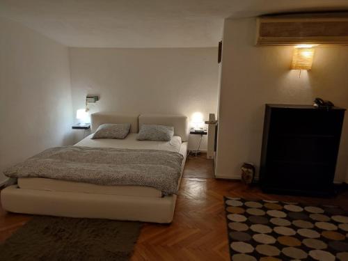 a bedroom with a white bed and a television at Dorobanți Loft in Bucharest